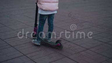 在街上骑滑板车的女孩。 滑板车腿的特写。